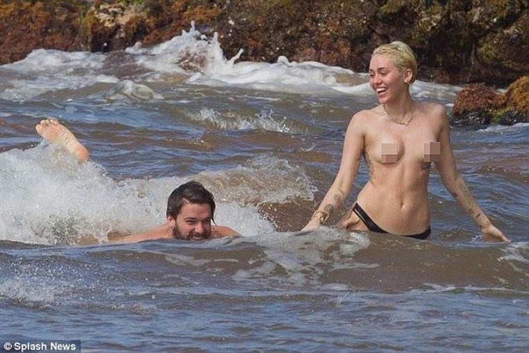 Miley Cyrus topless in the ocean with boyfriend Patrick Schwarzenegger 
